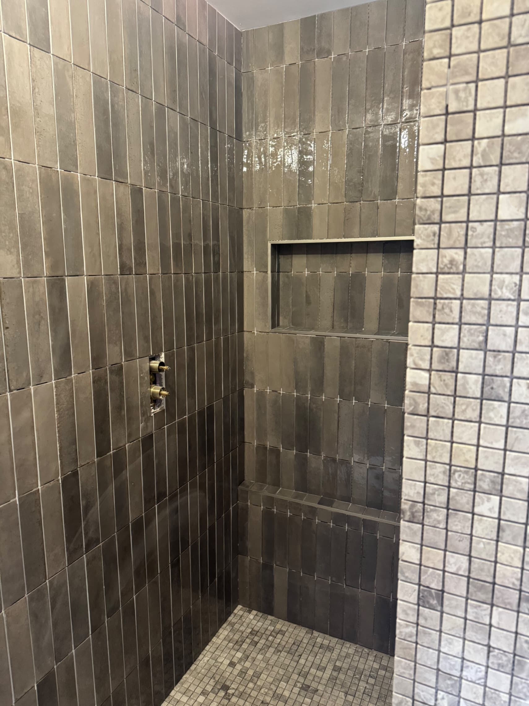 We've got all the vertical metro tiles up on the walls and the niche is finished — it's looking great and now ready for grouting.
